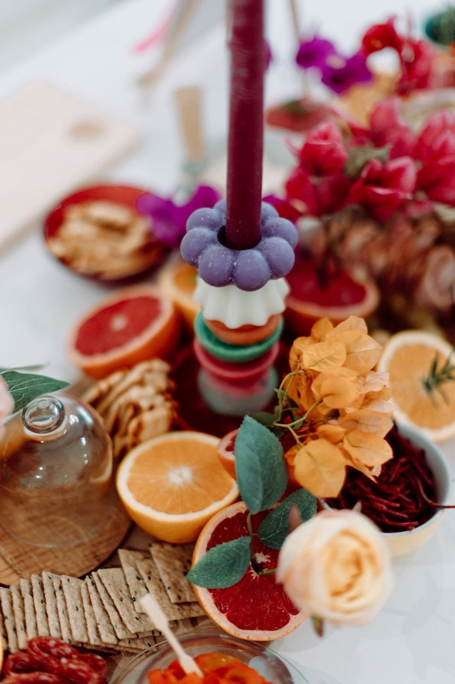 Close-up of a lilac scalloped candle piece holding a plum taper