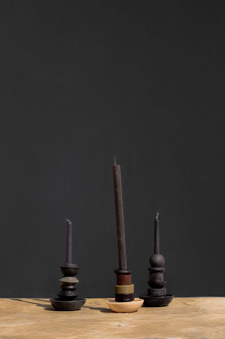 Three stacked candles in aubergine and olive tones