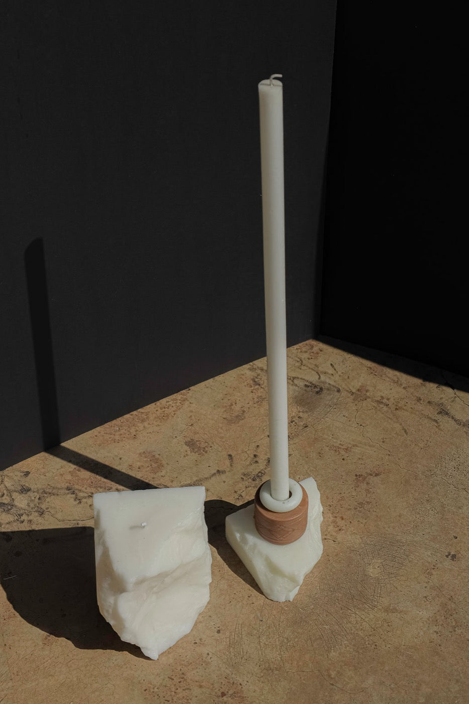 Ivory taper in a terracotta ring set on a wax block in hard sunlight